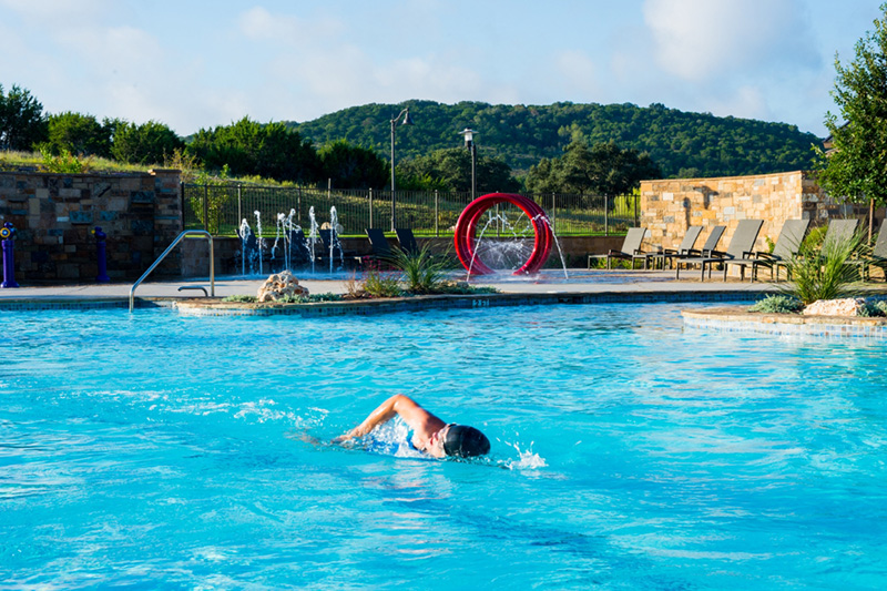 Swimmer swims laps in Sweetwater Club pool,  Sweetwater community Austin, TX